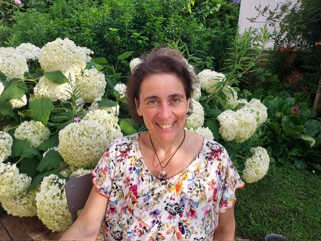 Lisa Cutard souriante devant des hortensias blancs