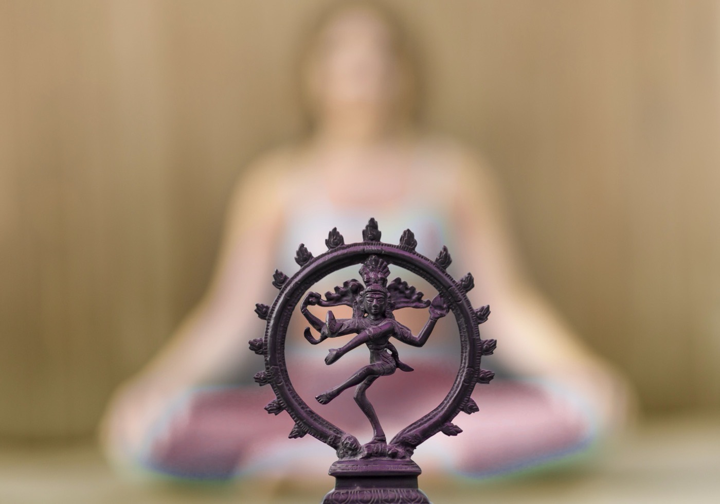 Statue de Shiva Nataraja devant une personne en méditation